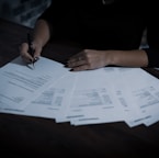 a woman sitting at a table with lots of papers