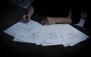 a woman sitting at a table with lots of papers