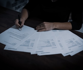 a woman sitting at a table with lots of papers