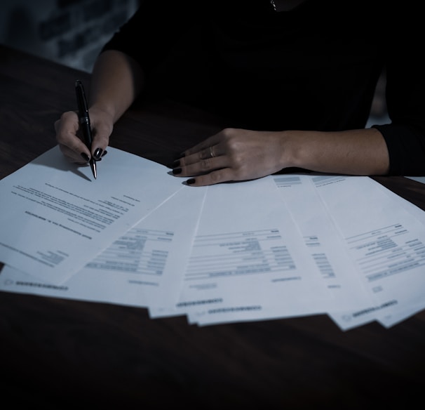 a woman sitting at a table with lots of papers