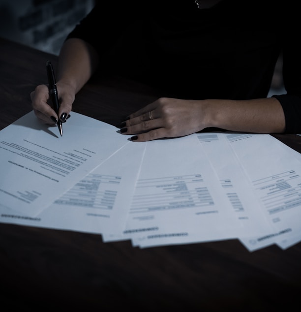 a woman sitting at a table with lots of papers