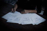 Close-up of a signed contract document on a wooden desk with a pen.
