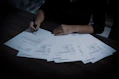 a woman sitting at a table with lots of papers