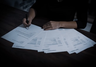 a woman sitting at a table with lots of papers