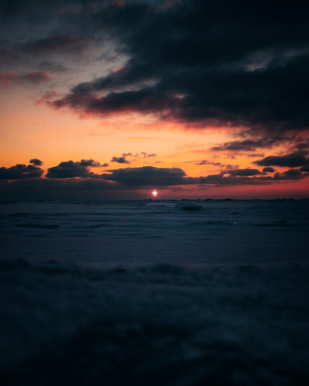 the sun is setting over the horizon of the ocean