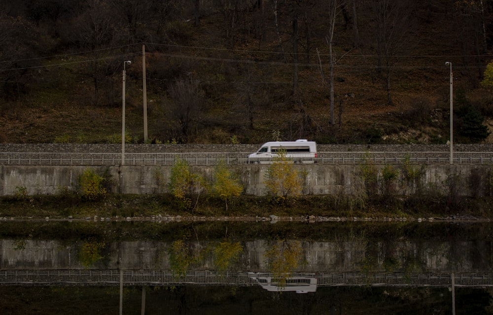 a van is parked next to a body of water