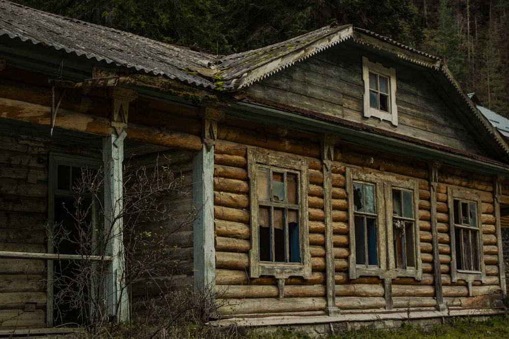 an old log cabin with a metal roof