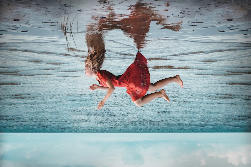 a woman in a red dress is floating in the water
