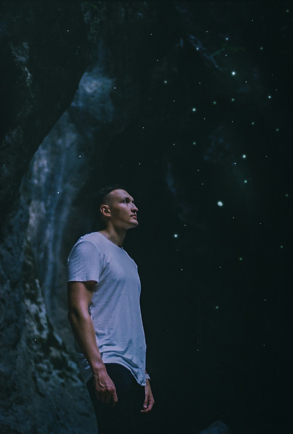 a man standing in front of a rock formation