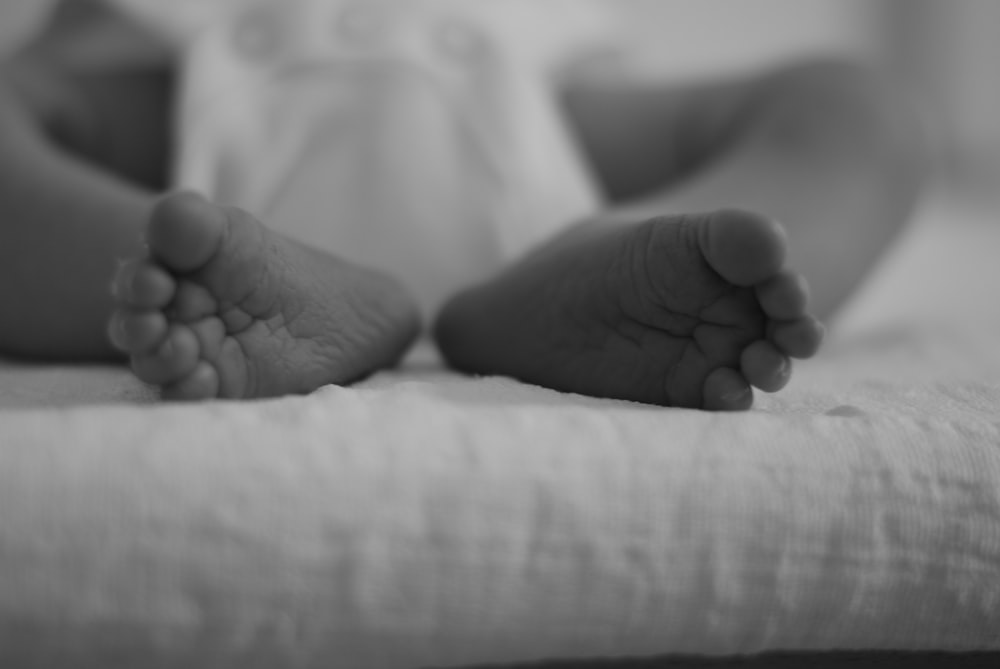 a black and white photo of a baby's feet