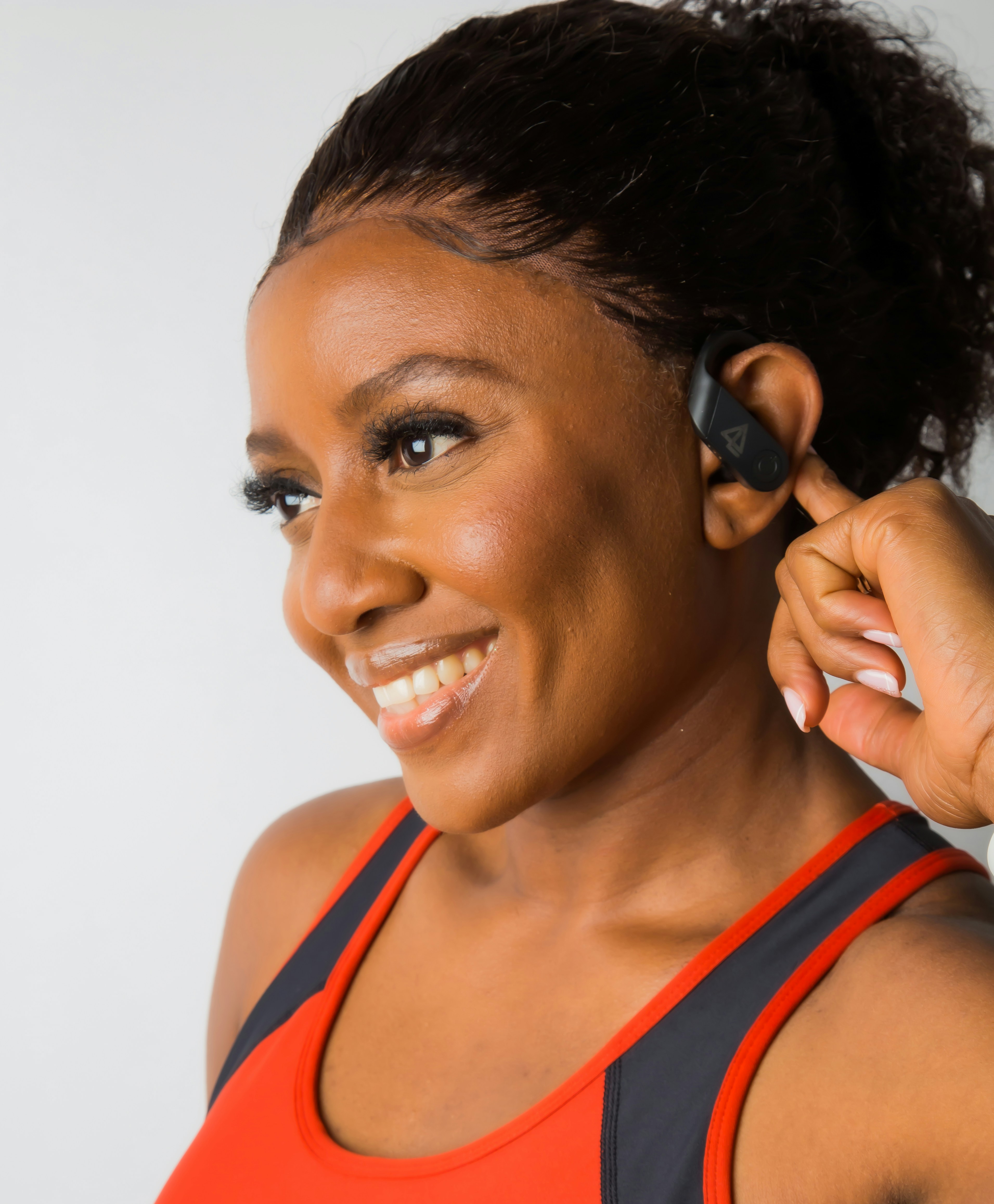 a woman is smiling and holding a cell phone to her ear