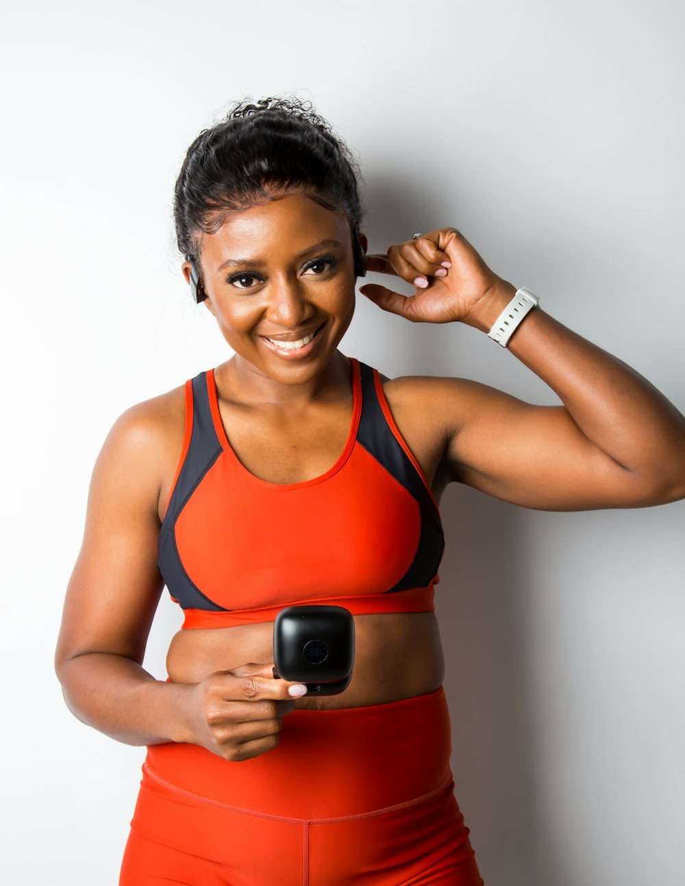 a woman in a sports bra top holding a cell phone