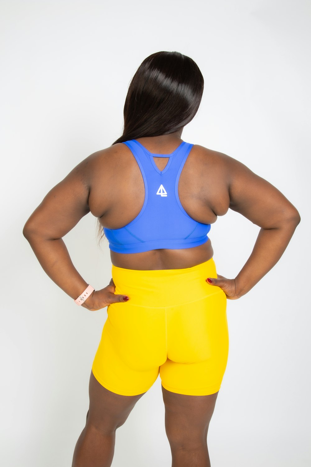 a woman in a blue top and yellow shorts