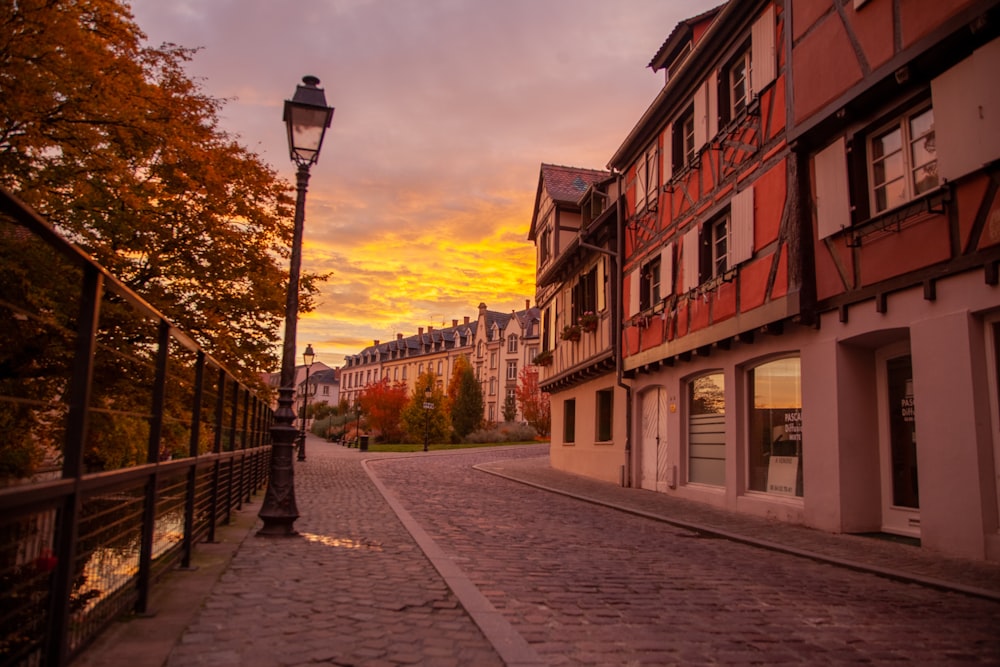 a cobblestone street with a lamp post in the foreground