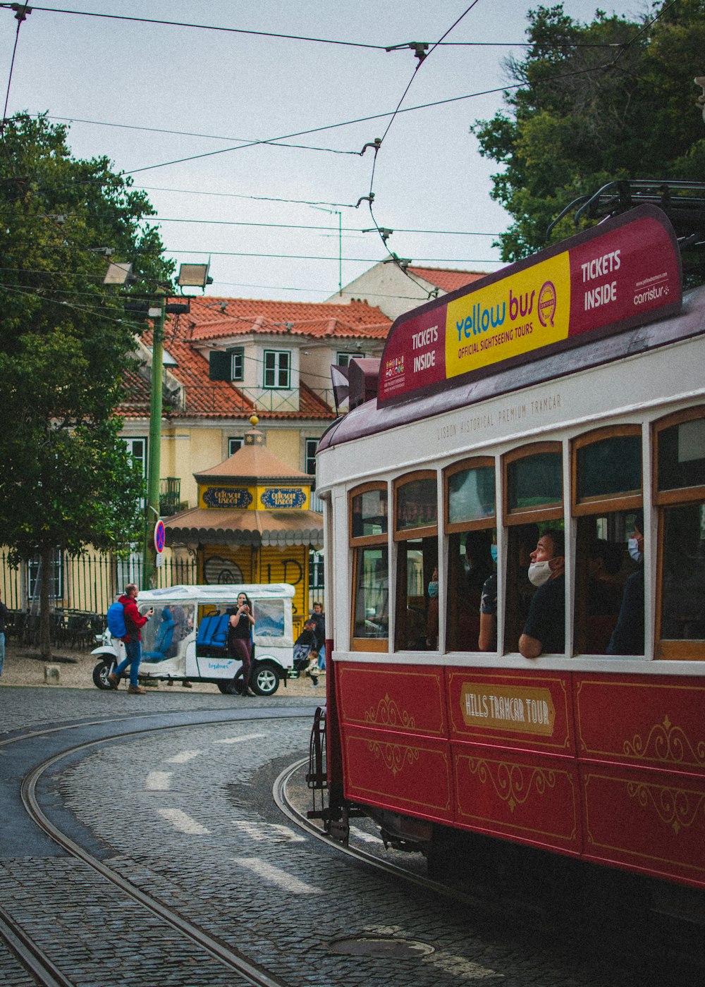 a red and white trolley car traveling down a street