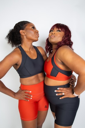 two women standing next to each other with their arms around each other
