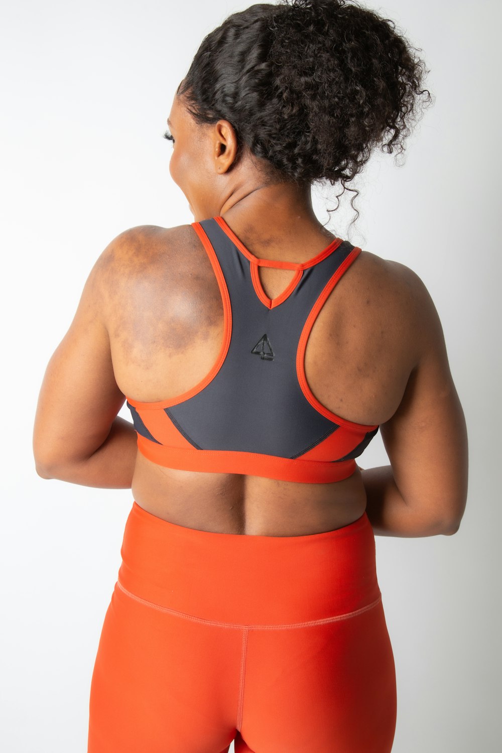 a woman in an orange sports bra top
