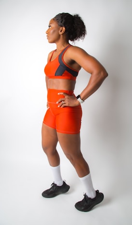 a woman in an orange sports suit posing for a picture
