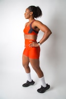 a woman in an orange sports suit posing for a picture