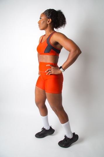 a woman in an orange sports suit posing for a picture