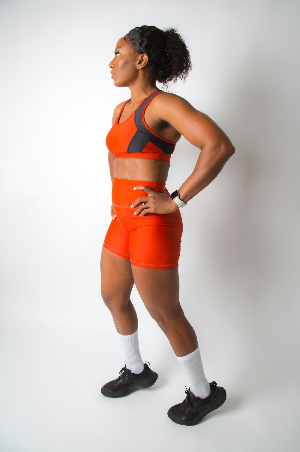 a woman in an orange sports suit posing for a picture