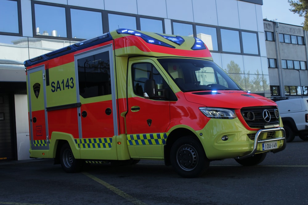 a red and yellow ambulance parked in a parking lot