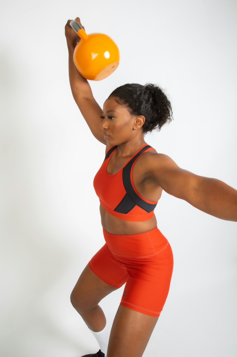 a woman in a sports bra top and shorts holding a ball