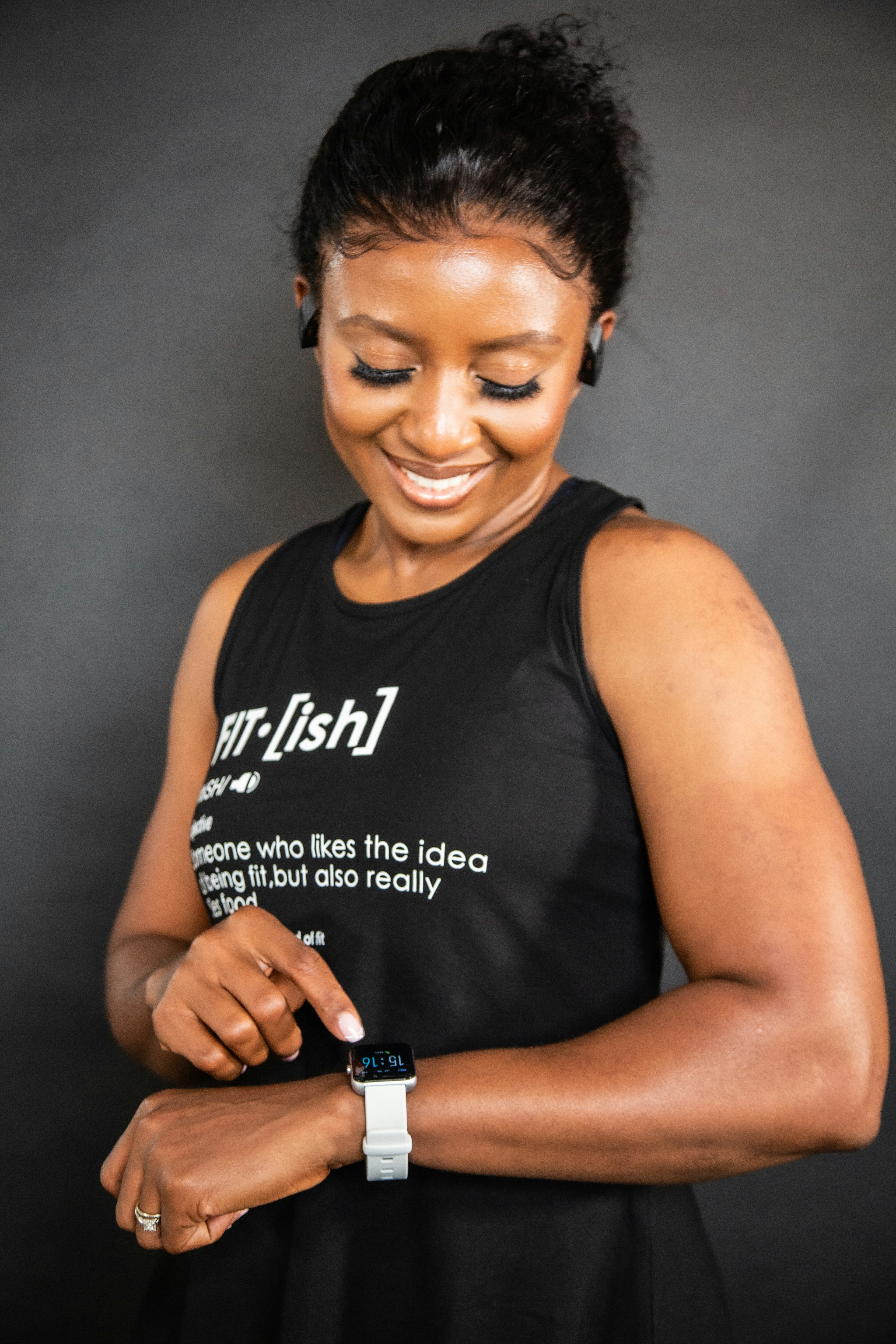 a woman is smiling and holding a smart phone