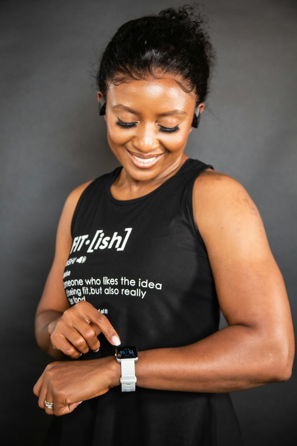 a woman is smiling and holding a smart phone