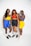 Three individuals pose confidently together, all wearing colorful, athletic attire. Each person sports a different variation of vibrant workout gear, including shorts in blue and yellow, and tops in similar shades with red accents. They stand against a plain white background, showcasing their sneakers and athletic watches. Their expressions convey strength and unity.