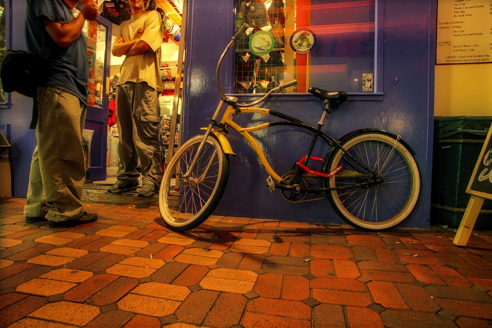 a man standing next to a bike in front of a store