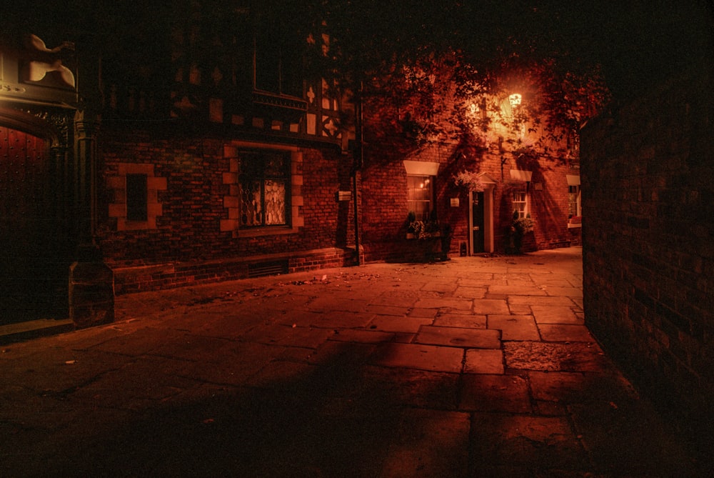 a dark alley way with a brick building at night