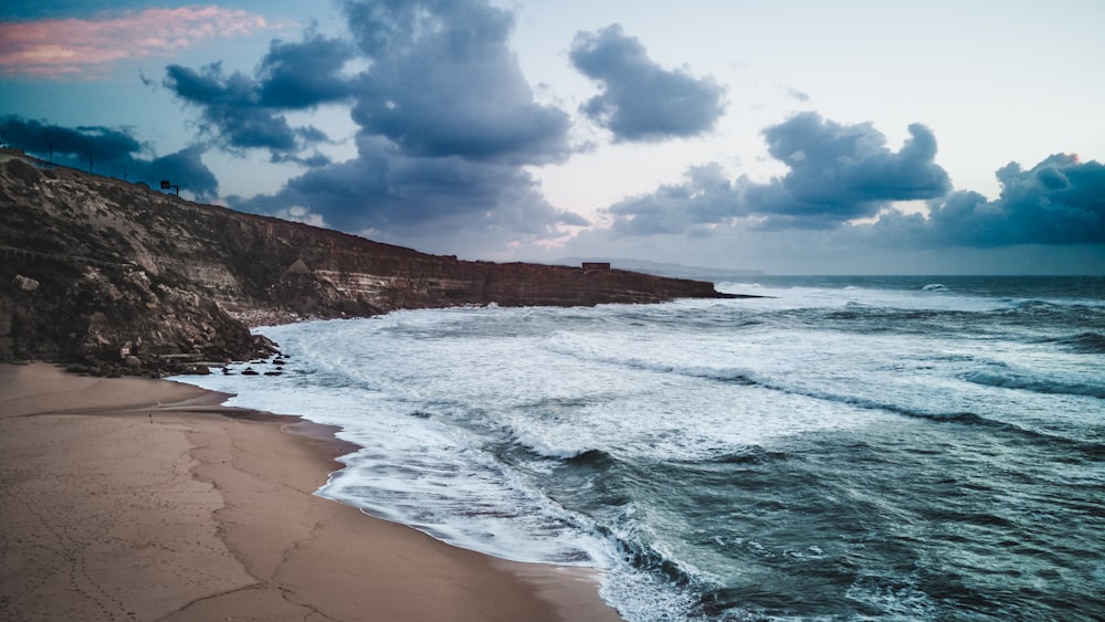 a view of a beach with waves coming in to shore