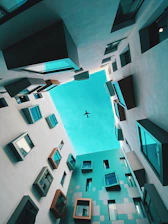 an airplane is flying through the sky between two buildings