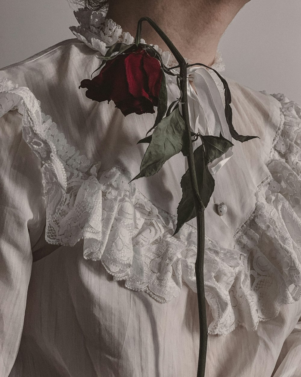 a woman with a rose attached to her neck