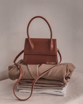 A stylish leather handbag displayed on a wooden table with natural light.
