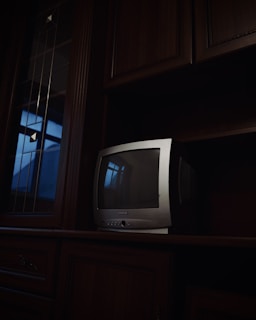 a small tv sitting on top of a wooden shelf