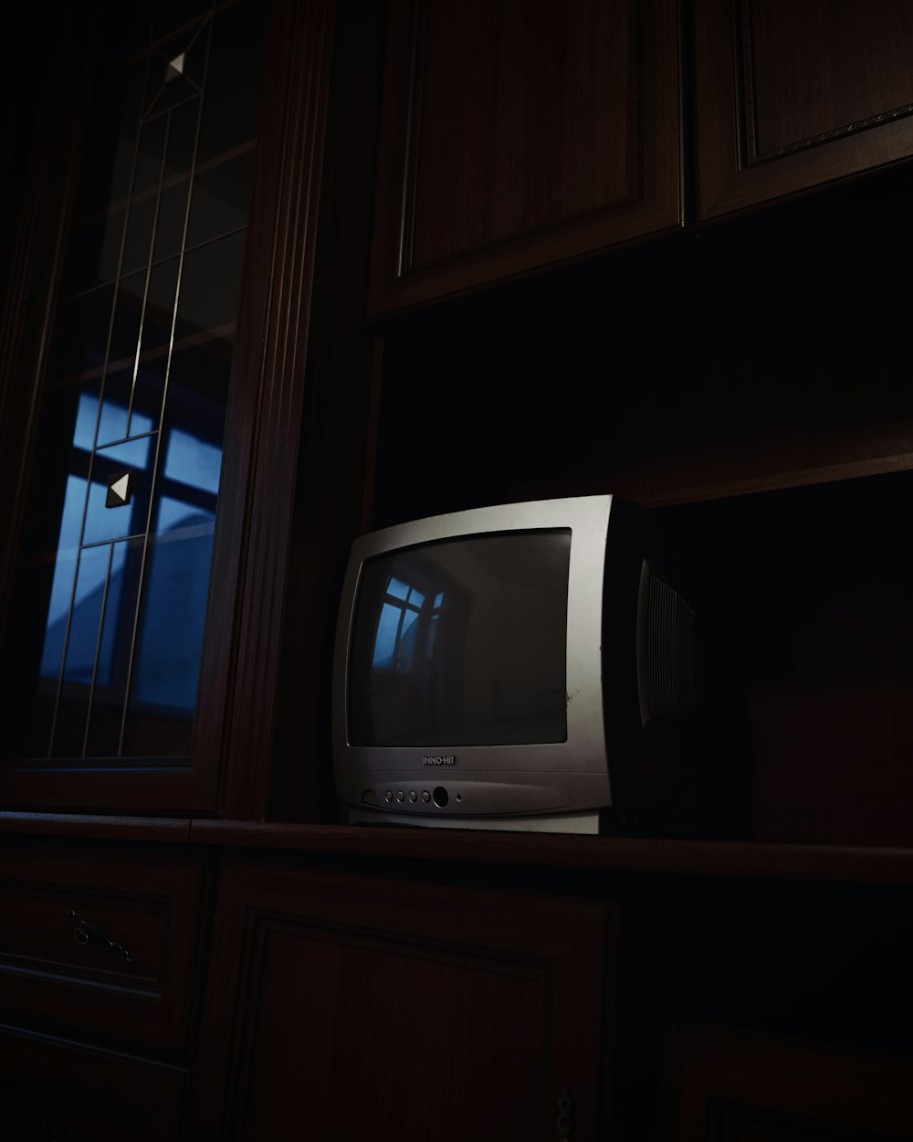 a small tv sitting on top of a wooden shelf