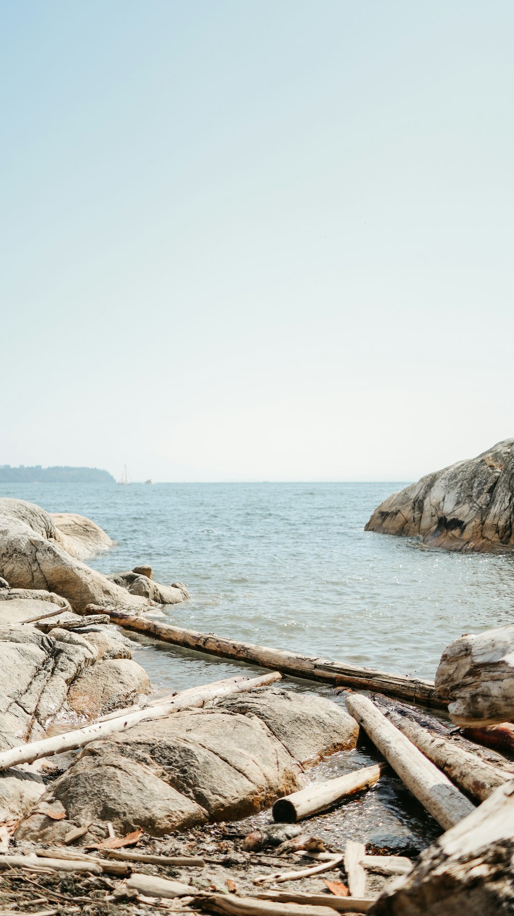 a person standing on a rocky beach next to a body of water