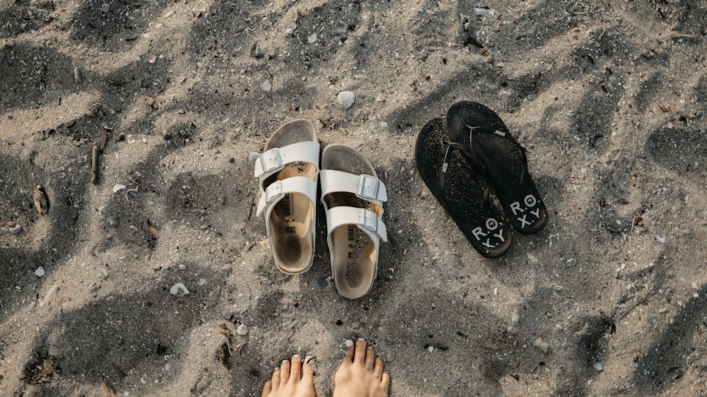 ein Paar Sandalen auf einem Sandstrand sitzen