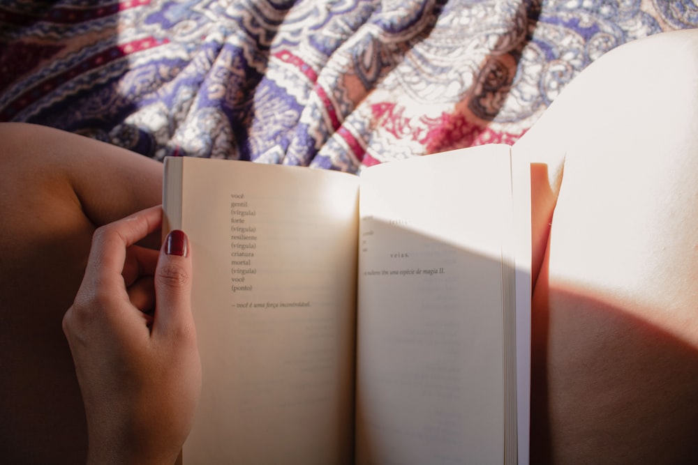 a person is reading a book on a bed