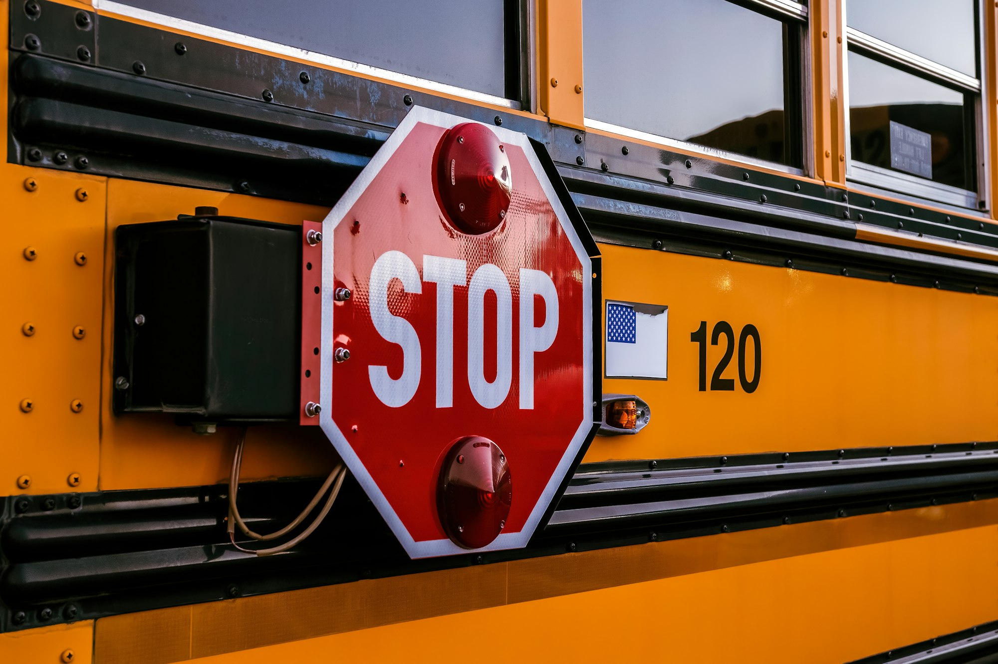 a stop sign attached to the side of a school bus
