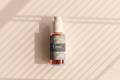 A cosmetic bottle with a pump is positioned against a background with diagonal light and shadow patterns. The bottle features a decorative label with intricate designs and the word 'Cosmetic' prominently displayed.