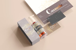 A coordinated set of cosmetic product branding materials includes a pump bottle, a rectangular box, business cards, and a leaflet. The design features elegant floral patterns in gold over grey and beige backgrounds, with the word 'Cosmetic' prominently displayed in a mix of white and copper colors.