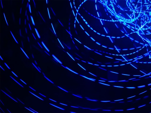 A series of bright blue light trails in circular motions against a dark background, creating a dynamic and energetic visual effect.