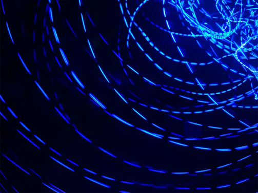 Abstract glowing circular lens with electric-blue light trails on a dark background.