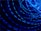 A series of bright blue light trails in circular motions against a dark background, creating a dynamic and energetic visual effect.