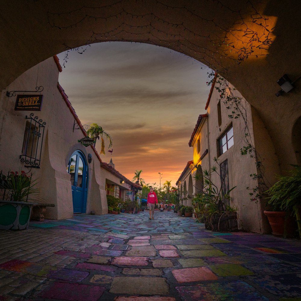 a person is walking down a cobblestone street