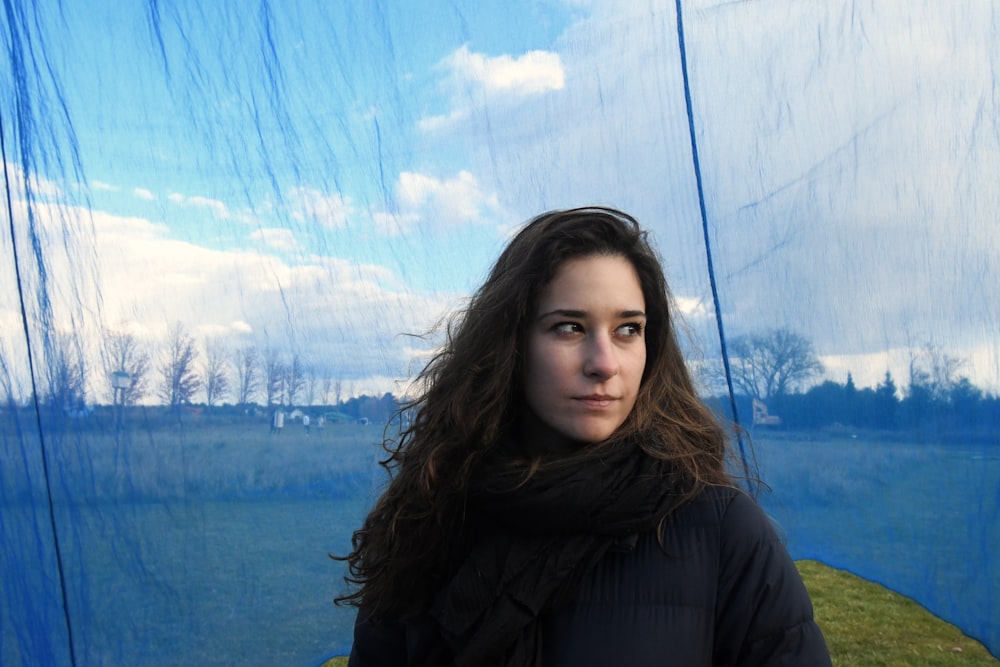 a woman standing in front of a blue curtain