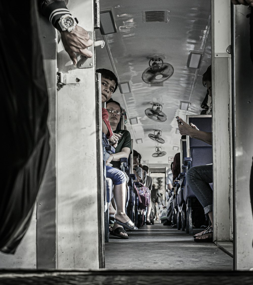 a group of people sitting on a train next to each other